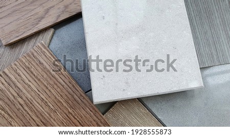 close up combination of interior material containing set of artficial stone and wooden veneer samples. quartz stone and wooden laminated samples palette background. kitchen countertops color samples.