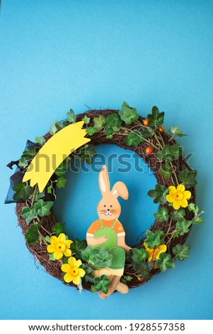 wreath with yellow flowers and easter bunny, easter decoration, copy space, vertical shot