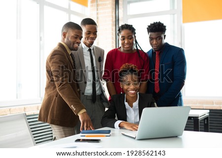 team of young african people in the office at the table with a laptop  Royalty-Free Stock Photo #1928562143