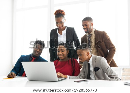 team of young african people in the office at the table with a laptop  Royalty-Free Stock Photo #1928565773