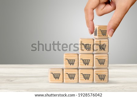 Sale volume increase to make a business grow,  wooden cube with shopping cart symbol. Royalty-Free Stock Photo #1928576042