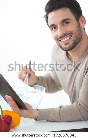 trendy man using a tablet for a recipe