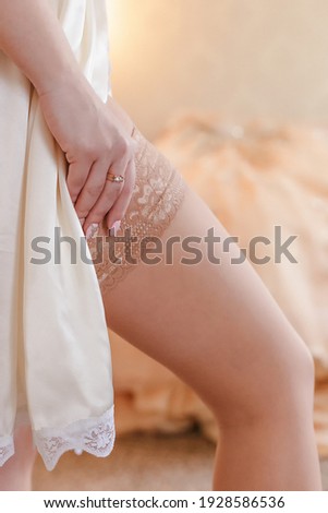 Beautiful, sweet, smiling blonde bride in a hotel room wearing stockings.