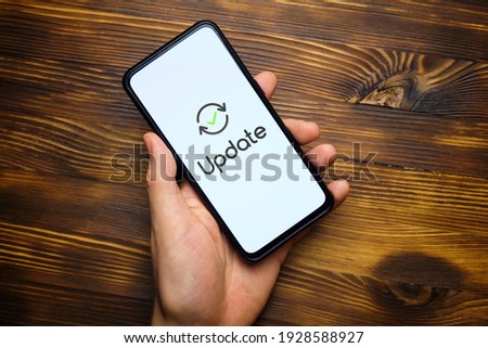 Person hand holds smartphone after system update. Royalty-Free Stock Photo #1928588927