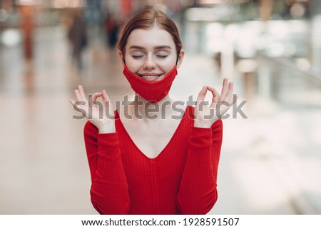 Portrait of young woman in protective medical face mask at shopping mall. Yoga, calm, zen and meditation a covid-19 pandemia concept