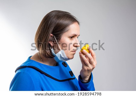 Anosmia or smell blindness, loss of the ability to smell, one of the possible symptoms of covid-19, infectious disease caused by corona virus. Man Trying to Sense Smell of a Lemon, side view. Royalty-Free Stock Photo #1928594798