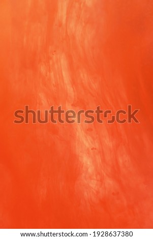 Colorful orange ink that dissolves in water. Abstract orange paint background