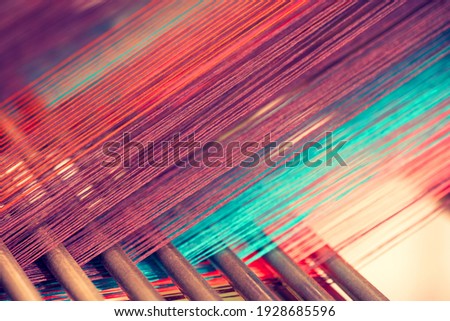 Multicolored straight strands texture background, sewing equipment, loom equipment at a garment factory Royalty-Free Stock Photo #1928685596