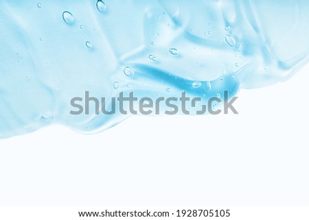 Cream gel blue transparent cosmetic sample with bubbles isolated on white background. Face serum texture. Clear skincare product smudge closeup. Hand sanitizer, hygiene liquid gel. Copy space