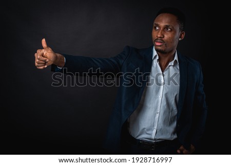 handsome handsome african american man in suit showing ok sign, on dark background. Cool man making ok symbol. Business success concept