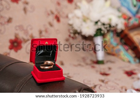Pair of wedding rings in red box on brown background