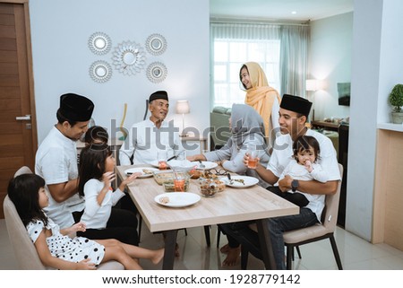muslim asian family and grandparents having break fasting on ramadan. iftar dinner break Royalty-Free Stock Photo #1928779142