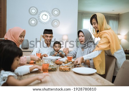 muslim asian family and grandparents having break fasting on ramadan. iftar dinner break Royalty-Free Stock Photo #1928780810