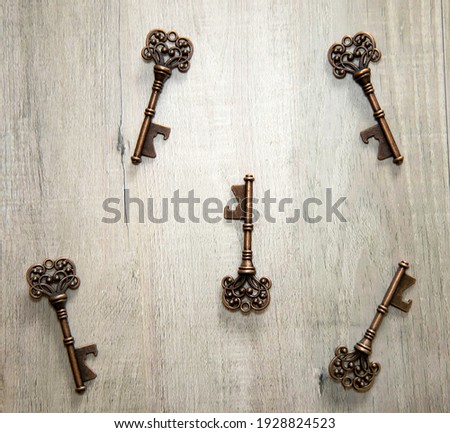 Five vintage bronze keys scattered on a wooden surface.