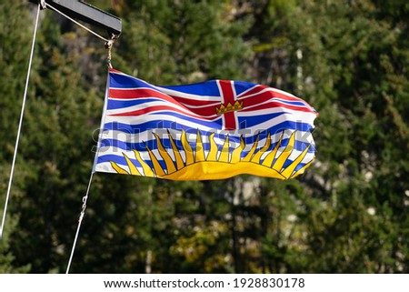 British Columbia Flag Flying Against Trees in the Background