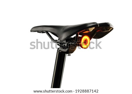 Close-up of bicycle saddle and illuminated tail light on white background Royalty-Free Stock Photo #1928887142