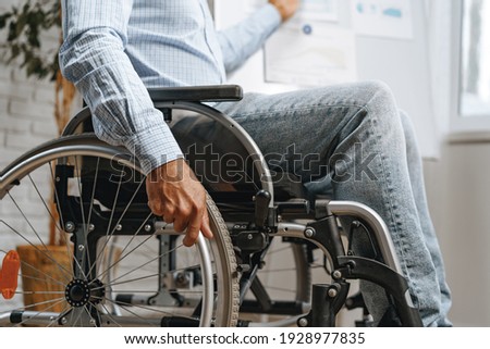 Unrecognizable disabled man sitting in a wheelchair Royalty-Free Stock Photo #1928977835