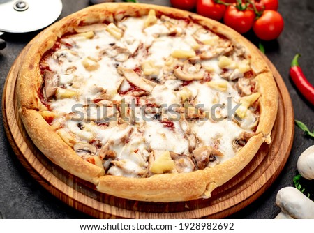 pizza with chicken mushrooms and pineapple on a stone background