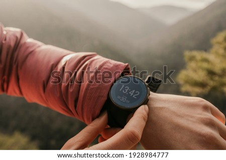 Woman looking app on sportwatch. Runner with heart rate monitor sports smart watch. Checking performance, GPS position or heart rate pulse Royalty-Free Stock Photo #1928984777