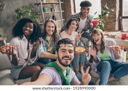 Photo portrait of funny overjoyed friends in dormitory eating pizza showing v-sign smiling taking selfie