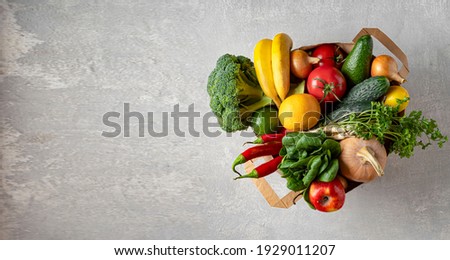 Banner Paper bag with eco friendly products on gray concrete Royalty-Free Stock Photo #1929011207