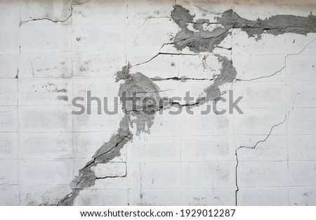 A brick wall with many cracks fixing by rough cement.  It shows construction problem and low quality of workmanship.  Background, textures, industrial, renovation categories. Royalty-Free Stock Photo #1929012287