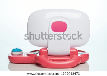Red plastic laptop for kids back view isolated on white studio background