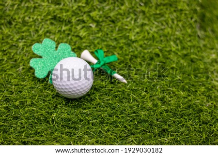 Golf ball for St. Patrick's Day is on green grass