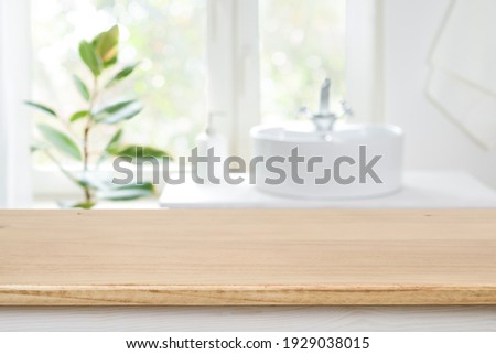 Bathroom sink near window with wooden table in front focus Royalty-Free Stock Photo #1929038015