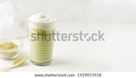 Matcha tea with milk on a light gray background. Copy space. Banner