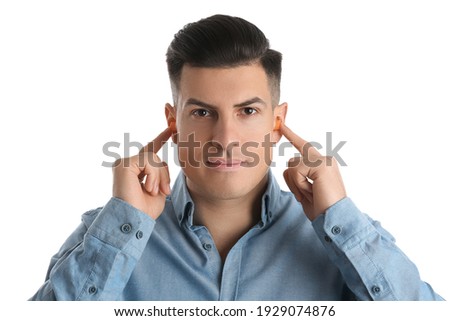 Man inserting foam ear plugs on white background