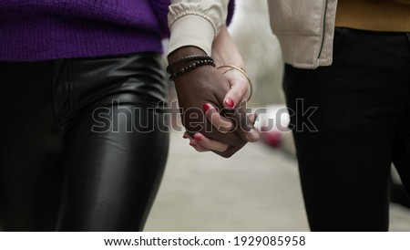 Diverse interracial young couple joining hands outside. Diversity concept union