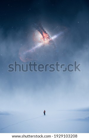 A man standing in snow and fog looking up at a cosmic event in the sky. The nebula in the image furnished by NASA.