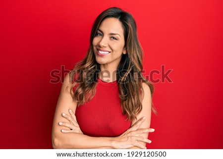 Young latin woman wearing casual clothes happy face smiling with crossed arms looking at the camera. positive person. 