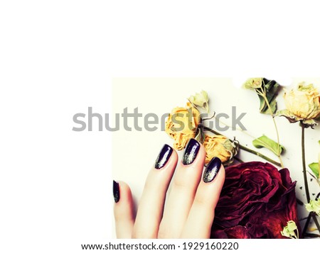 close up picture of manicure nails with dry flower red rose