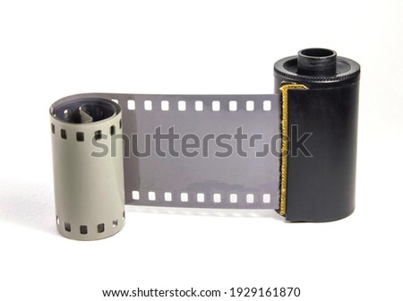 Roll of undeveloped 35 mm, black and white negative photographic film on a white background 
