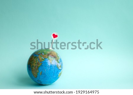 Globe with a heart icon on a blue background in honor of earth day, 21 march world earth day peacekeeping and humanistic, 22 april international earth day ecological Royalty-Free Stock Photo #1929164975