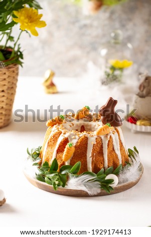 Easter lemon cake with icing and easter decoration. Easter gugelhupf cake with marzipan carrots and chocolate easter bunny Royalty-Free Stock Photo #1929174413