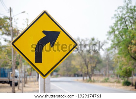 A black arrow traffic sign on a yellow background to bend to the right . Royalty-Free Stock Photo #1929174761