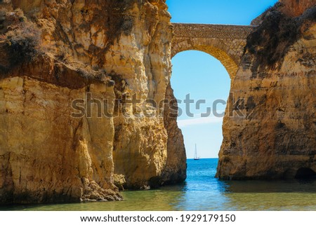Detailed View of arched bridge with sailboat in Students Beach in Lagos, Algarve, Portugal Royalty-Free Stock Photo #1929179150