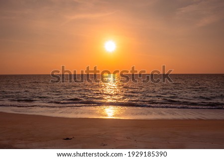 colorful dark orange sunset and ocean wave and cloudy sky in beautiful summer day. sunset image edited with little grain to make more vintage. sunset background can be used to represents many ideas