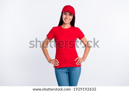 Photo of young happy smiling cheerful delivery service woman in red t-shirt and cap isolated on grey color background Royalty-Free Stock Photo #1929192632