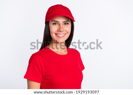 Photo of young cheerful smiling lovely beautiful service delivery woman in red cap and t-shirt isolated on grey color background