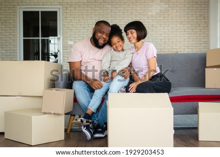 Mixed Race families are sitting on the sofa for rest after moving to a new house on the first day after buying real estate.  Concept of starting a new life for a new family.
