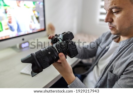 Accounting work in a marketing and advertising agency. A middle-aged man checks photos taken at the shooting, approval of materials for clients. Agency life, home office during corona virus time