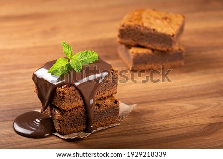 Chocolate brownies with chocolate sauce and mint leaves. Image with selective focus.