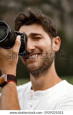Professional photographer taking picture. young man with a camera. a man takes a photo with a professional camera in nature.