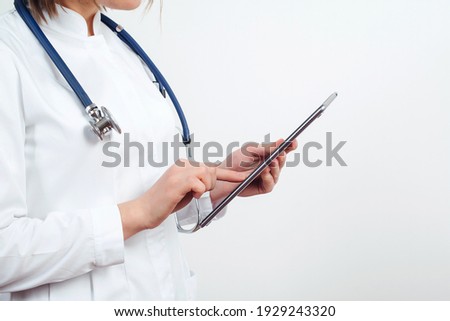 Woman doctor using digital tablet at clinic. Doctor reading patient report. Mock-up with copy space. Healthcare And Medicine.