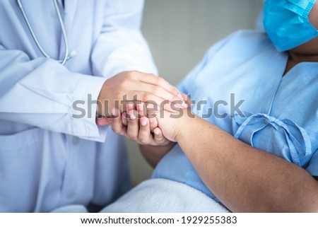 The doctor hold hands patient Which wearing a surgical mask and lying in the patient's bed, to encourage To fight the disease And cheer to receive treatment, to people and health care concept. Royalty-Free Stock Photo #1929255383