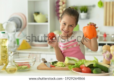 Close up portrait of cute girl preparing delicious fresh salad in kitchen